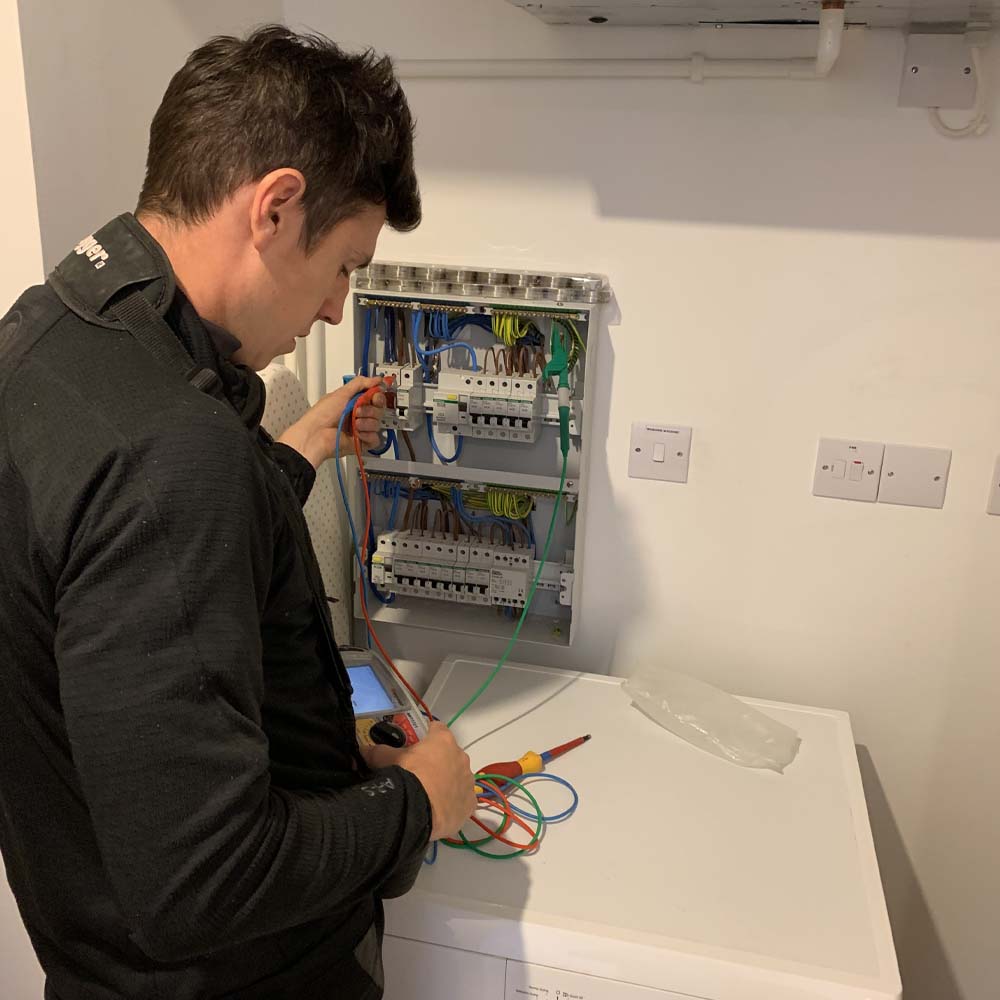 APP Electrical team member carrying out EICR report inside of south wales home.