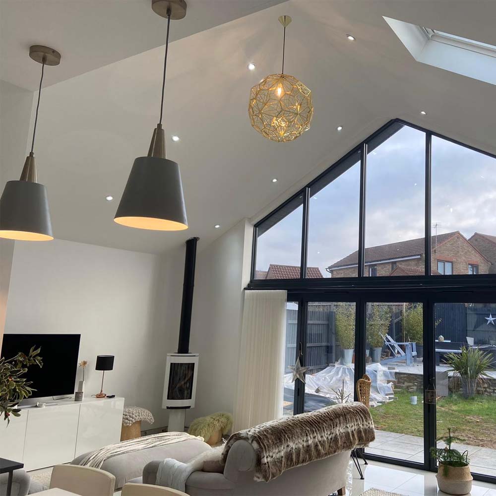 Completed internal lighting installation inside of home featuring hanging lights and downlights.