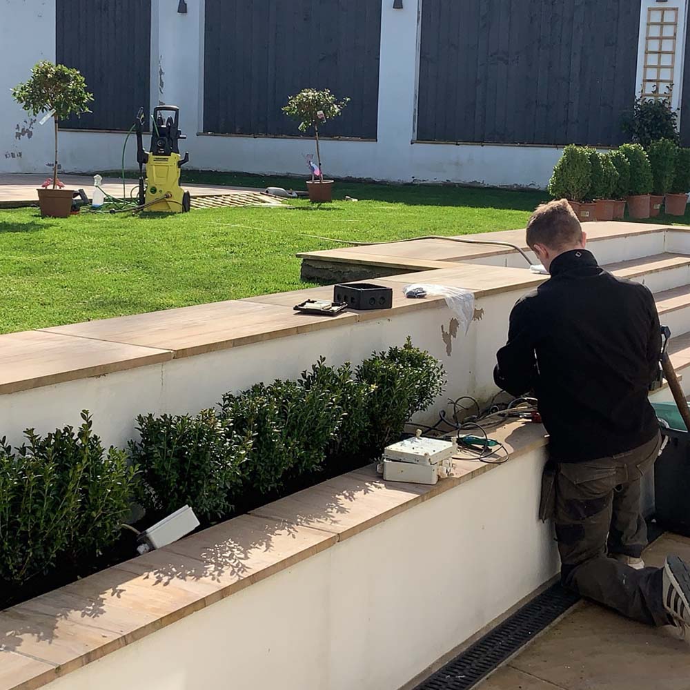 APP Electrical team member installing outdoor electrics for homeowner.